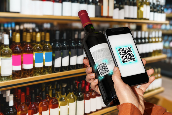 Scanning e-label of wine bottle by smart phone in liquor store. in Tout savoir sur les règles d&rsquo;étiquetage du vin 